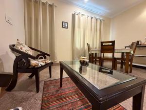 a living room with a glass table and chairs at The Annexe in Greater Noida