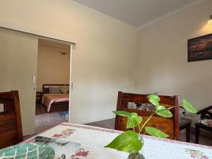 a room with a bed and a plant on a table at The Annexe in Greater Noida +2 photos