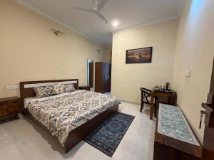 a bedroom with a bed and a table in it at The Annexe in Greater Noida