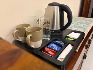 a tray with two cups and a coffee maker at The Annexe in Greater Noida