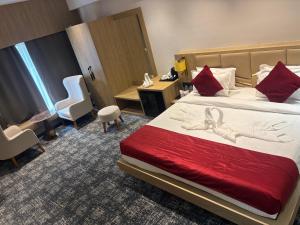 a hotel room with a bed and a desk and chairs at The Chinmaye Grand in Bhāgalpur +43 photos