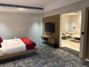 a bedroom with a bed and a flat screen tv at The Chinmaye Grand in Bhāgalpur