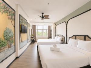a hotel room with two beds and a tv at Asteria Ocean Residence in Danang