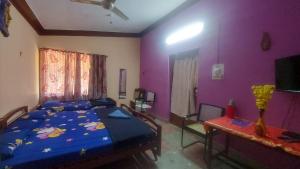 a bedroom with a bed and a purple wall at Honey Palace Homestay in Madikeri