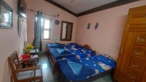 a bedroom with two beds and a window at Honey Palace Homestay in Madikeri