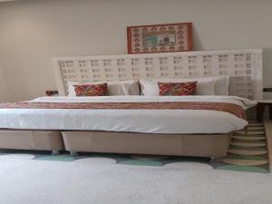 a large bed in a bedroom with a large bedvisor at DanCenter Parijat Villas & Suites Udaipur in Udaipur