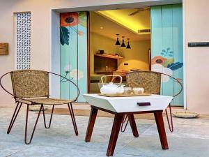 two chairs and a table in front of a kitchen at DanCenter Parijat Villas & Suites Udaipur in Udaipur
