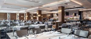 a dining room with white tables and chairs at Hotel AR Golf Almerimar in Almerimar