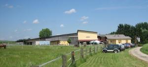 a farm with cars parked in a field and a fence at Zum Alten Pferdestall in Eppingen