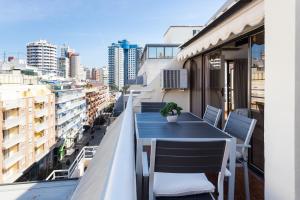 a balcony with a blue table and chairs on a building at Apartamentos Edf AUREA y Edf SARVACHO in Benidorm
