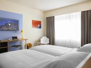 a hotel room with a white bed and a window at ibis Styles Athens Routes in Athens