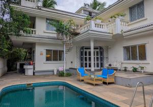 a house with a swimming pool in front of it at Beach villa Candolim in Candolim