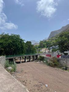 a bridge over a dirt road with mountains in the background at Refúgio NO Stress in Paul +3 photos