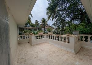 a balcony with a white railing and some trees at Beach villa Candolim in Candolim