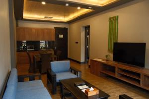 a living room with a couch and a television at JL World Hotel Dili in Dili