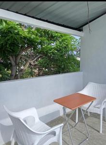 a table and chairs on a balcony with a window at Rian Rest in Dehiwala