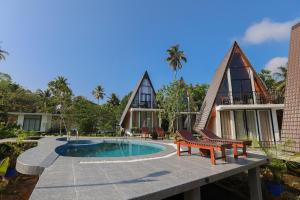 a resort with a swimming pool and two chairs at The Glade in Weligama