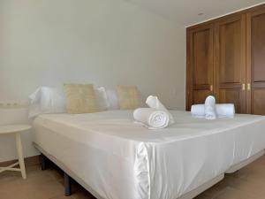 a white bed with towels on top of it at Villa Can Alaya in Santa Eularia des Riu