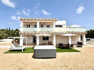 a white house with a table and chairs in front of it at Villa Can Alaya in Santa Eularia des Riu