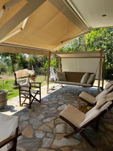 a patio with a couch and chairs under a tent at Country Vila in Nikiti