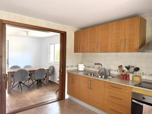 a kitchen with wooden cabinets and a table with chairs at Villa Can Alaya in Santa Eularia des Riu