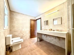 a bathroom with a toilet and two sinks at Villa Can Alaya in Santa Eularia des Riu +30 photos