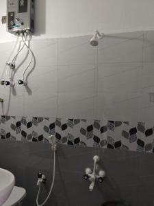 a bathroom with a shower with a hose in it at VIDYA Homestay in Hampi