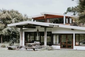a house with a picnic table in front of it at Kanuka Terrace - Luxury Strawbale House in Kaikoura
