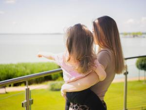 two women are standing next to a railing at Royal Martin's Apartment in Keszthely
