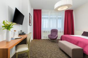 a hotel room with a pink bed and a desk at Brijuni Hotel Istra in Brijuni