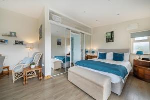 a bedroom with a king sized bed and a chair at Ashclose Lodge Annexe in Sherborne