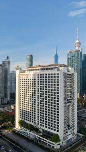 a large white building in the middle of a city at Hotel Maya Kuala Lumpur City Centre in Kuala Lumpur