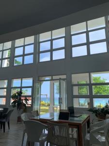 a room with a table and chairs and windows at Dapdap Shorelines Beachfront Villa in Camotes Islands +35 photos