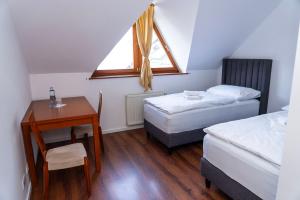 a bedroom with two beds and a desk and a window at Nidum - Šariš Park Hotel & Wellness in Prešov +23 photos