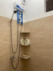 a shower in a bathroom with two bottles of soap at Dapdap Shorelines Beachfront Villa in Camotes Islands