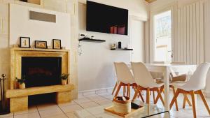 a living room with a table and chairs and a fireplace at Le Rivage, maison proche mer avec Spa in Les Sables-d'Olonne
