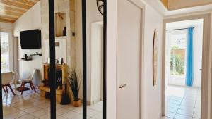two views of a living room with a door and a hallway at Le Rivage, maison proche mer avec Spa in Les Sables-d'Olonne