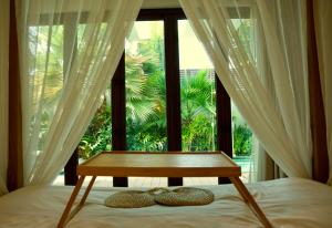 a bed with a table in front of a window at Okan Chalet in Barka +20 photos