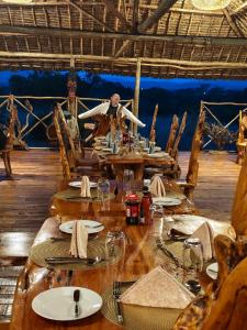 a long wooden table with plates of food on it at Veilscape Mara Camp in Masai Mara
