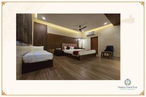 a hotel room with two beds and a chair at Temple Town Stay in Kanchipuram +20 photos