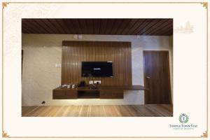 a room with a flat screen tv on a wall at Temple Town Stay in Kanchipuram