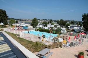 a large swimming pool with people in a resort at Mobile Home à Louannec in Louannec