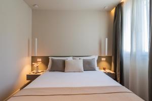 a bedroom with a large white bed with two lamps at The Circle Bike Residence by Rent All Como in Tavernerio