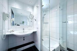 ein weißes Badezimmer mit Waschbecken und Dusche in der Unterkunft Best Western Premier IB Hotel Friedberger Warte in Frankfurt am Main