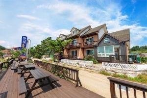 a row of benches on a boardwalk in front of a house at mongsanpo cueogpensyeon in Taean