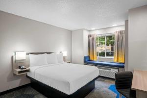 a bedroom with a bed and a chair and a window at Microtel Inn Georgetown - Lexington North in Georgetown +45 photos