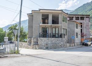 a house on the side of a street with a mountain at Muros Guesthouse in Mestia