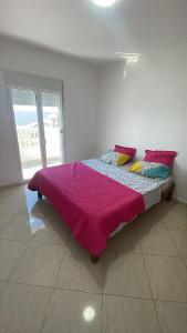 a bedroom with a bed with a purple blanket on it at Appartement proche mer 