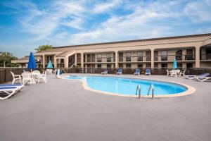 a hotel with a swimming pool in front of a building at Days Inn by Wyndham Norfolk Airport in Norfolk