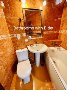 a bathroom with a toilet and a sink and a tub at Hotel British House in Tbilisi City +67 photos